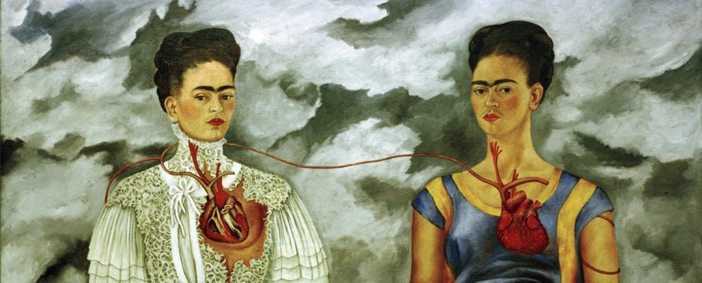 Dwie kobiety z połączonymi sercami na tle chmur. Jedna kobieta nosi białą, koronkową wiktoriańską suknię z odsłoniętym sercem, podczas gdy druga nosi niebieski, nowoczesny strój z odsłoniętym sercem. Serca są połączone pojedynczym naczyniem krwionośnym.