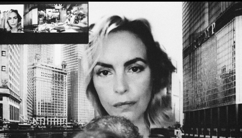 twarz kobiety pomiędzy budynkami miasta. Fotografia biało czarna.