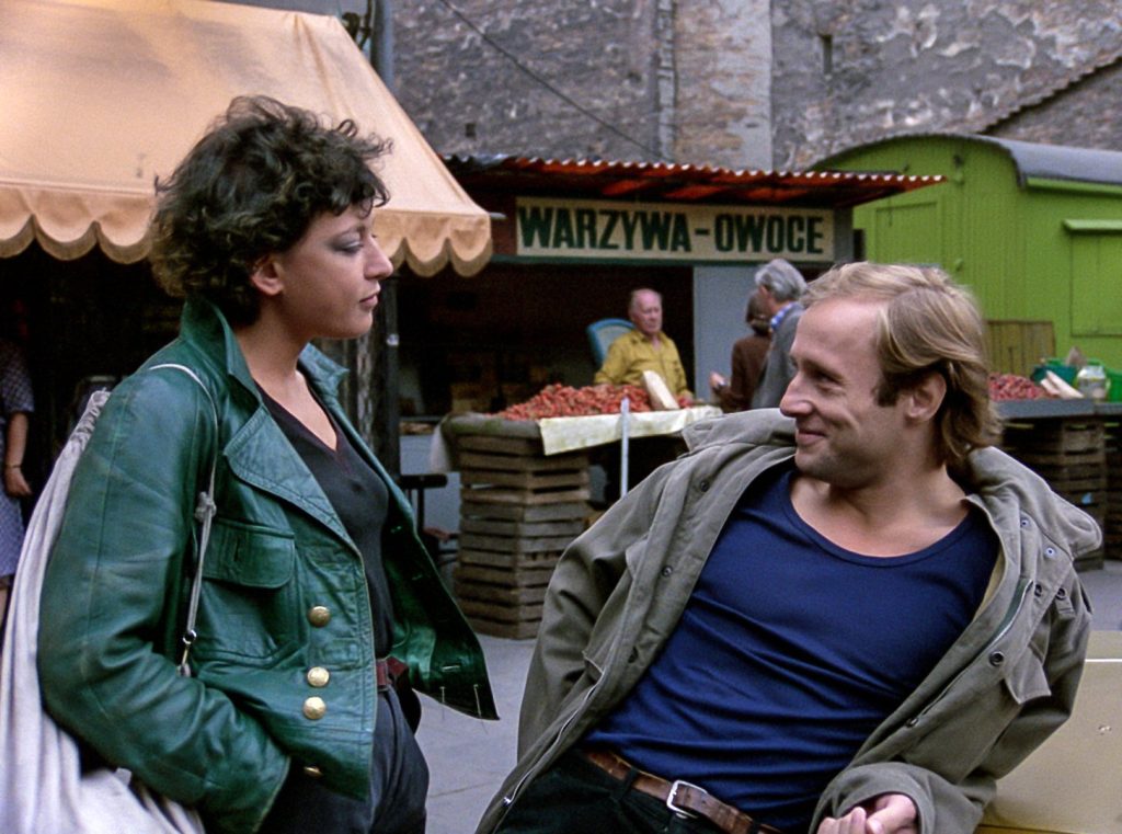 kobieta i mężczyzna rozmawiający na placu targowym. On w wesołym nastroju.