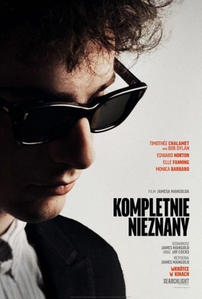 na szaym tle twarz męska z czarnymi okularami z pół-profilu. po prawej stronie czarny napis kompletnie nieznany